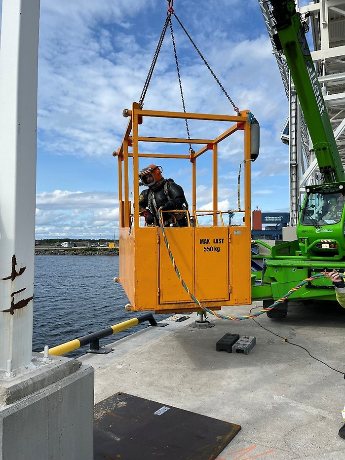 Höglyft som hjälper dykarna vid arbetet med färjepiren.
